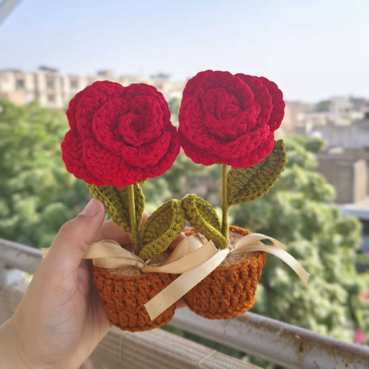 Handmade crochet red roses in a basket held against a cityscape background