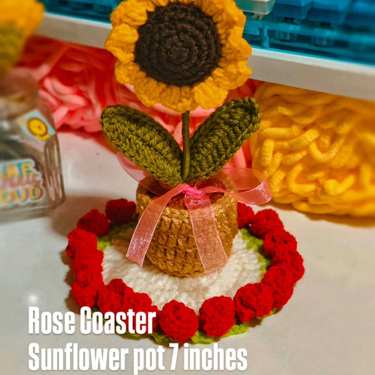 Crocheted sunflower pot with red roses on a white surface