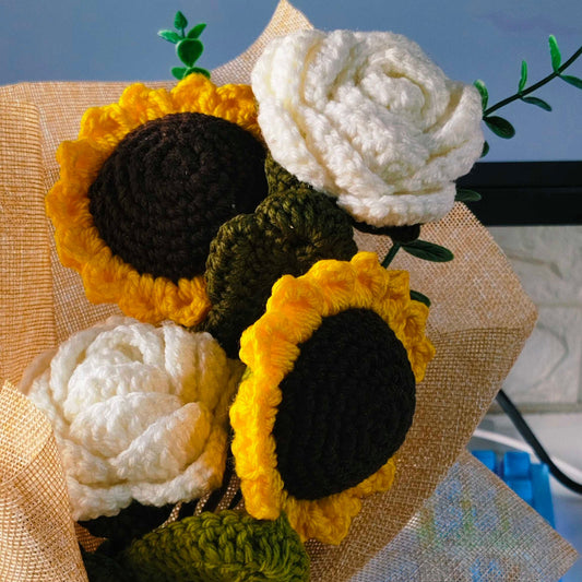 Bouquet of crocheted sunflowers and roses on a textured surface