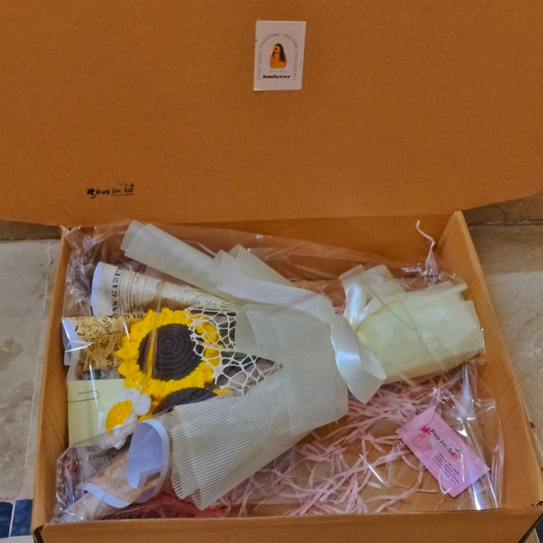 Open box containing a dress with a sunflower design on a beige surface