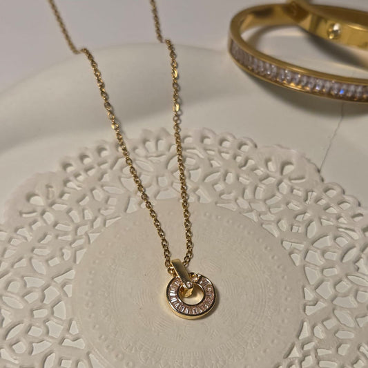 Gold necklace and bracelet on a decorative white surface