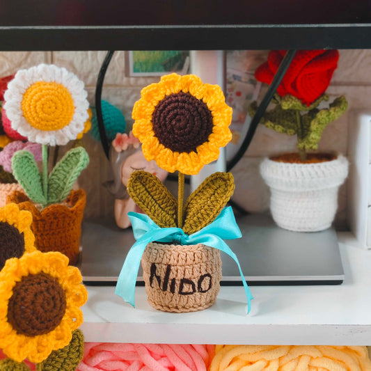 Crocheted sunflowers with a laptop in the background