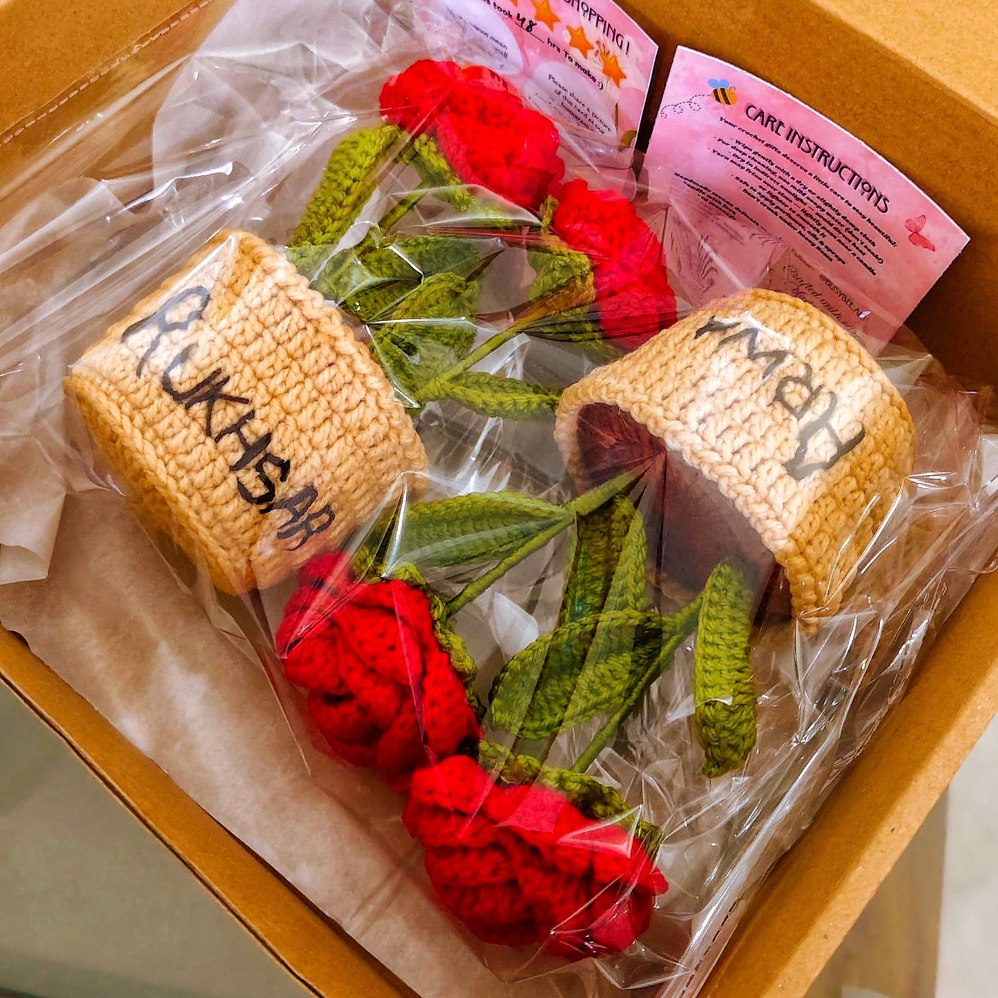 Bouquet of red roses in a box with personalized bread rolls and a card.