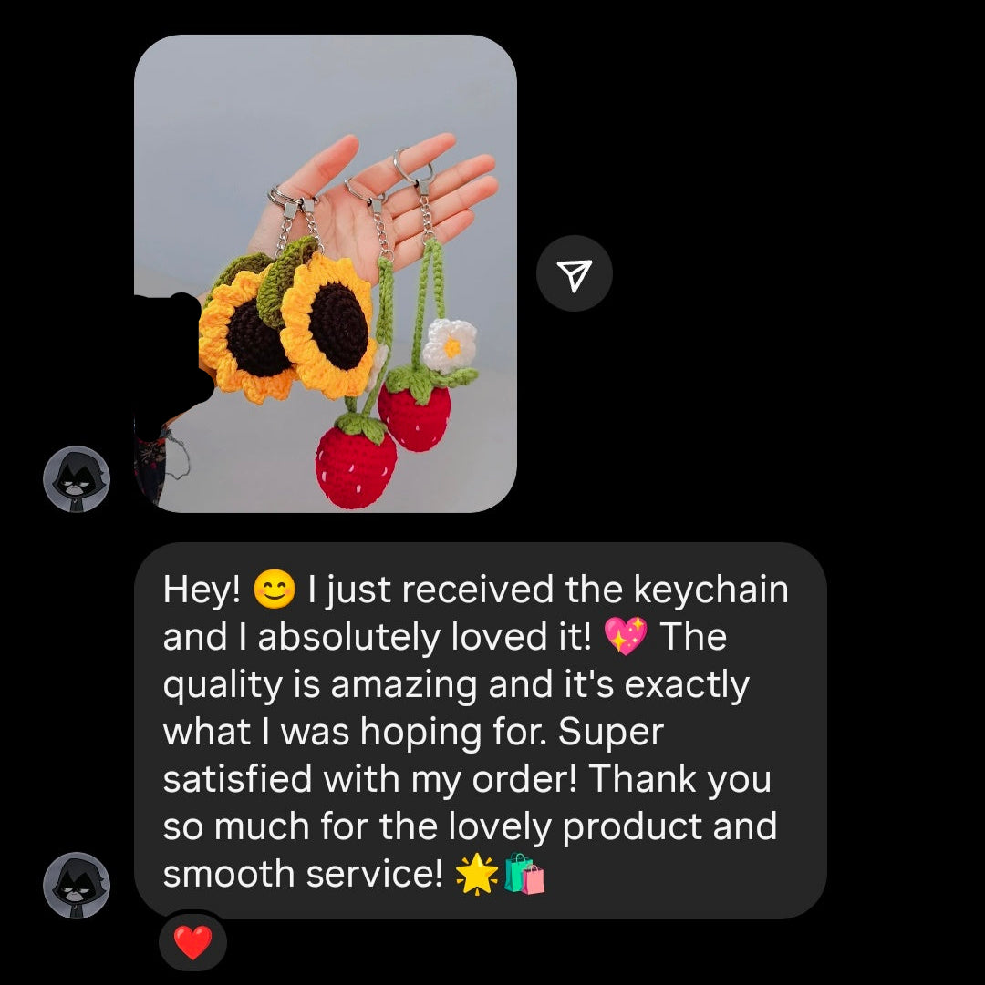 Hand holding a keychain with sunflower and strawberry designs, accompanied by a text message review.